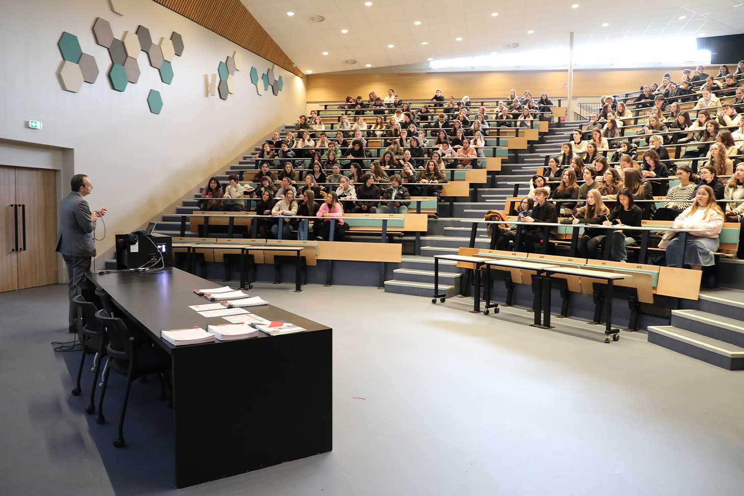 Un enseignant debout dans un amphi devant ses étudiants