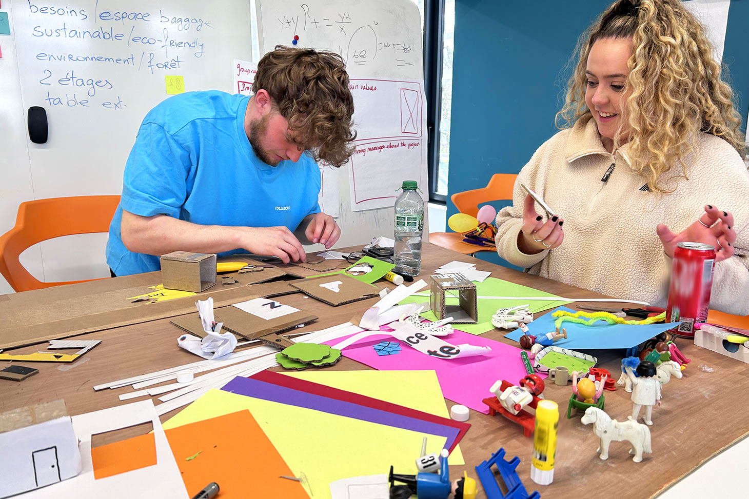 Un étudiant et une étudiante participent à un atelier créatif de la Desig Factory.