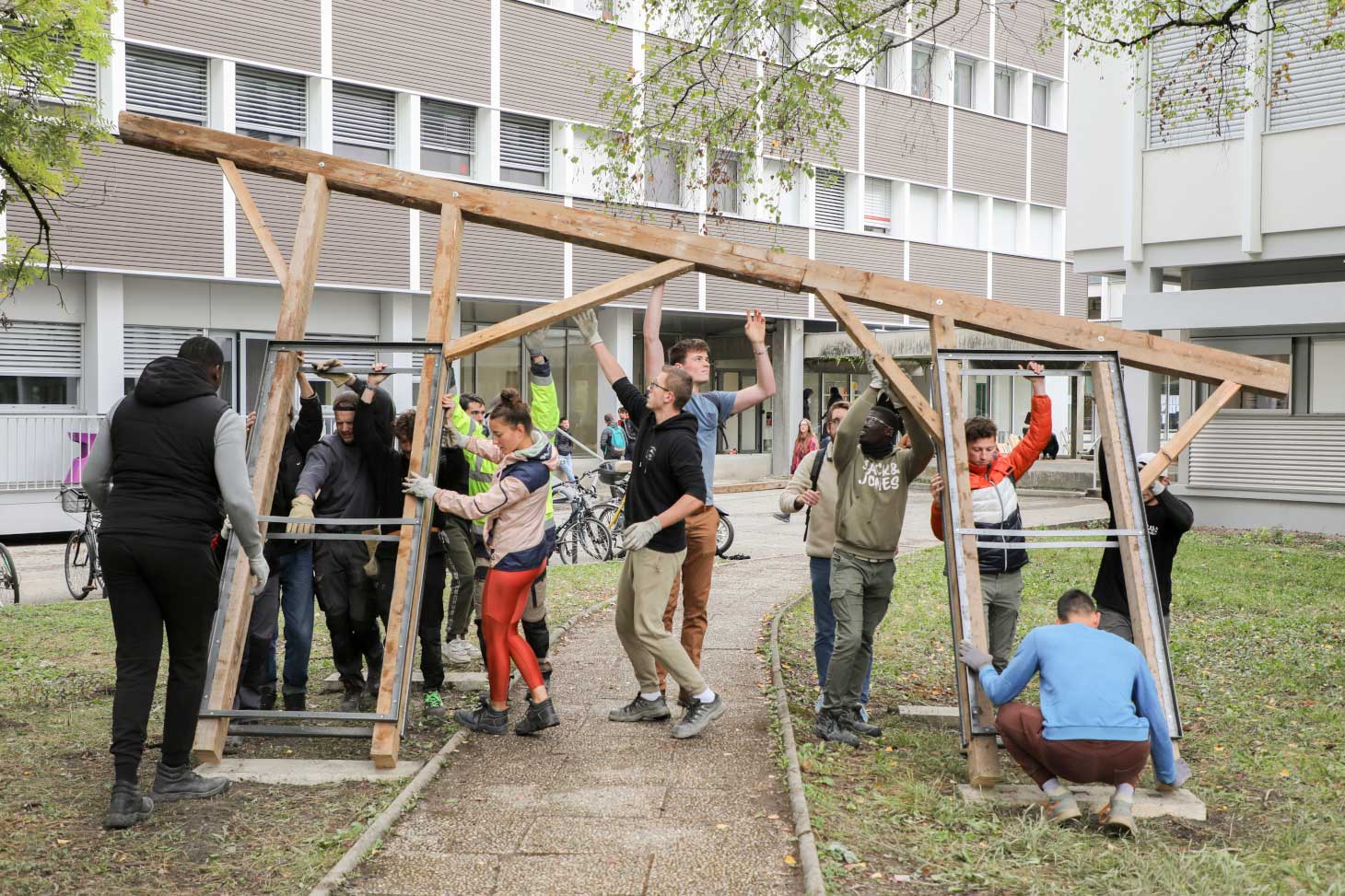 Les étudiantes et étudiants en action sur le chantier de construction en matériaux de réemploi devant le bâtiment Bergès sur le domaine universitaire