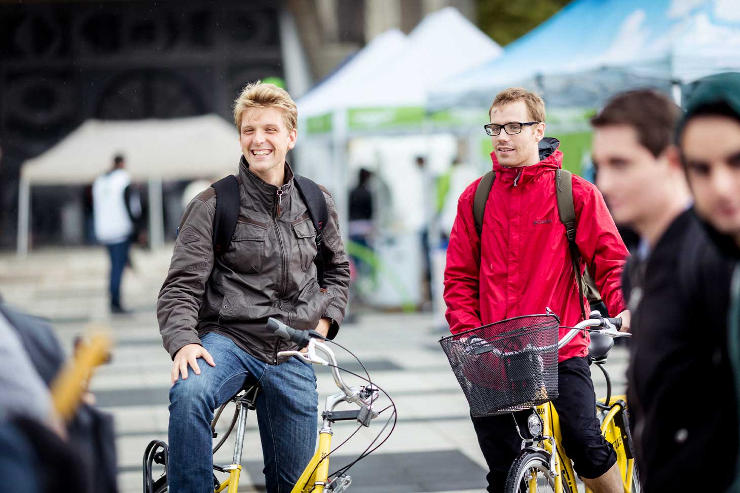 Deux étudiants souriants sur leurs vélos